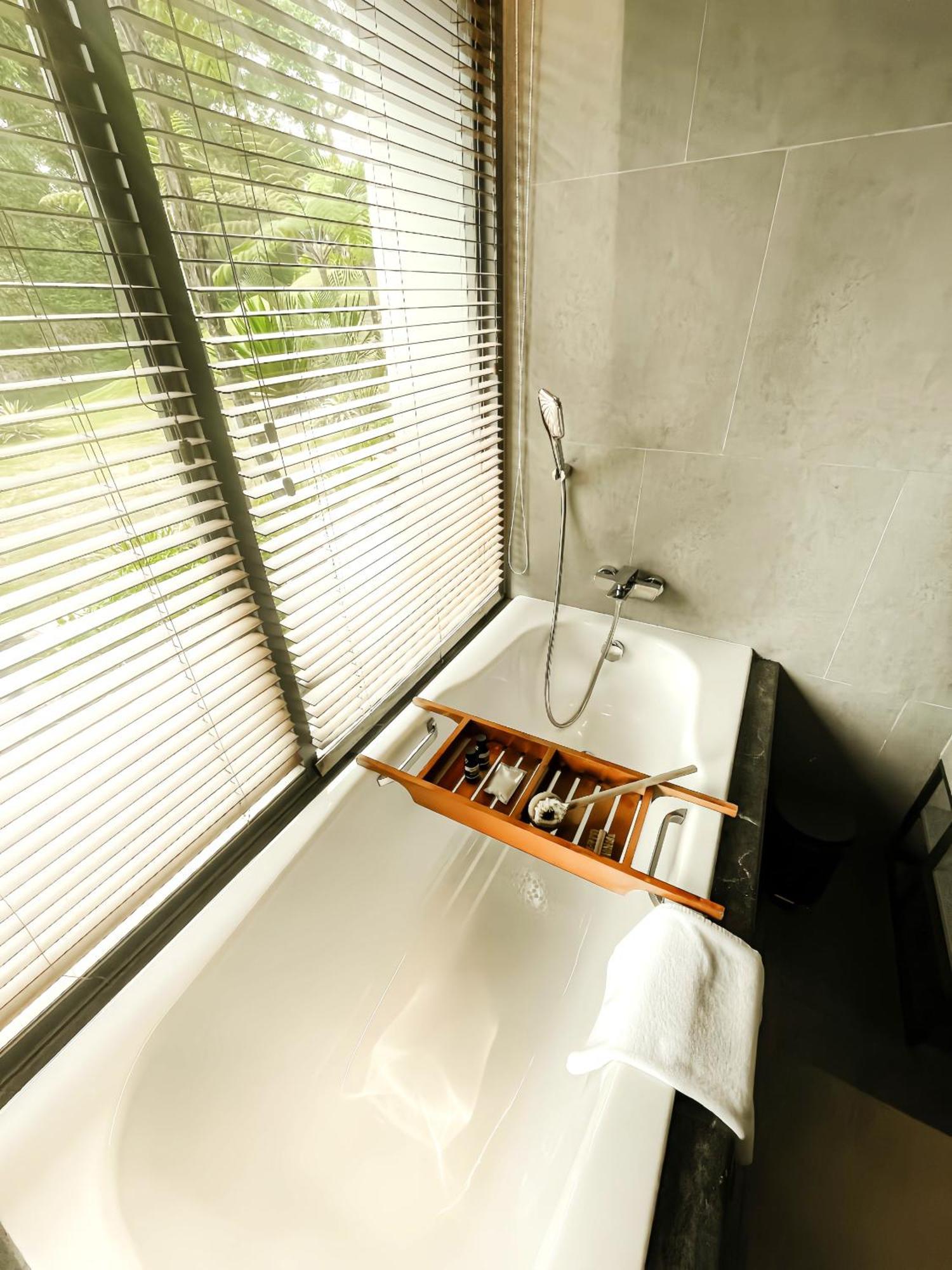 The Botanica Sanctuary Hotel Puncak Bilik gambar A bathtub with a shower